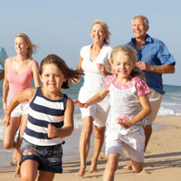 Multi generalational family runs on a beach